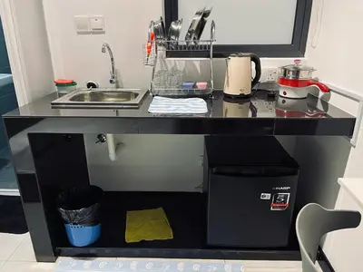 a black kitchen counter with a sink and a microwave at Neu suites advance HomeStay klcc in Kuala Lumpur