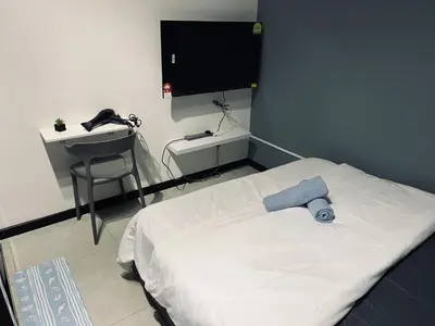 a bedroom with a bed and a desk and a television at Neu suites advance HomeStay klcc in Kuala Lumpur