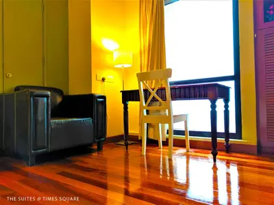 a living room with a chair and a desk at The Suites at Times Square KL by Robinsons in Kuala Lumpur