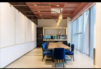 a conference room with a table and blue chairs at scatletz suites klcc by yatie in Kuala Lumpur