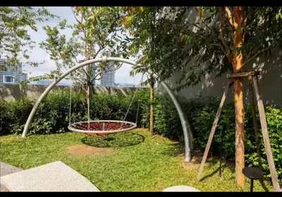 a swing in the grass next to a tree at scatletz suites klcc by yatie in Kuala Lumpur
