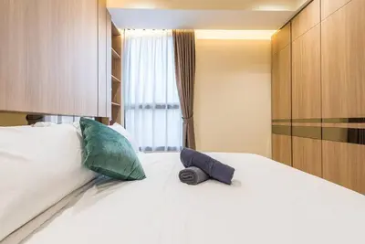 a bedroom with a white bed with two pillows and a window at Arcoris Mont Kiara 12# Deluxe 2 Bedroom # Coner with Balcony #1-4Pax in Kuala Lumpur