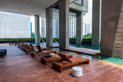a lobby with chairs and a pool in a building at Arcoris Mont Kiara 12# Deluxe 2 Bedroom # Coner with Balcony #1-4Pax in Kuala Lumpur