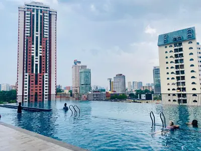 a pool with people in the water in a city at Chambers Residences ZFJ World in Kuala Lumpur