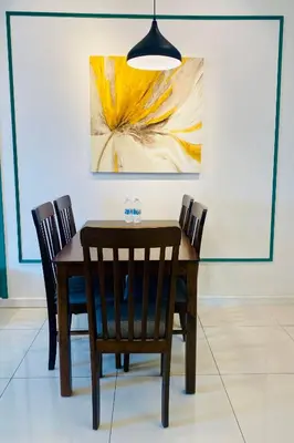 a dining room table with chairs and a painting at Chambers Residences ZFJ World in Kuala Lumpur
