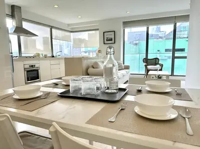 a kitchen with a table with plates and glasses on it at Bintang Fairlane Residence, KLCC & City Skyline View -2B1R in Kuala Lumpur