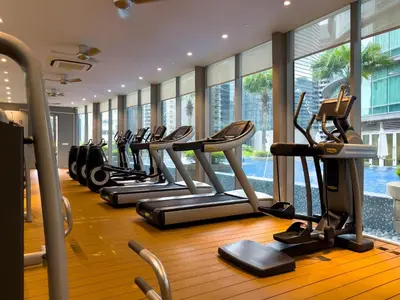 a row of treadmills in a gym with windows at Vortex Suites KLCC by Wakely Kuala Lumpur in Kuala Lumpur