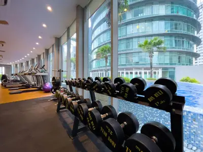 a row of dumbbells in a gym with a swimming pool at Vortex Suites KLCC by Wakely Kuala Lumpur in Kuala Lumpur
