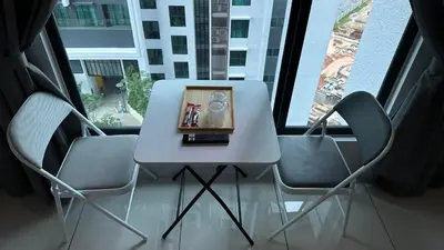 a white table and chairs in front of a window at Cozy Studio Kuala Lumpur by LH in Kuala Lumpur