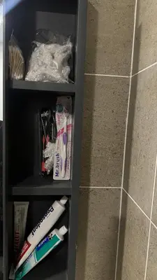 a black shelf with toothbrushes and toothpaste at Cozy Studio Kuala Lumpur by LH in Kuala Lumpur