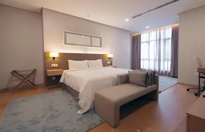 a bedroom with a large bed and a chair at Sfera Residence Kuala Lumpur City Centre in Kuala Lumpur