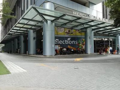 a large building with people sitting outside of it at Diamond Suite KL at Mercu Summer Suite KLCC in Kuala Lumpur