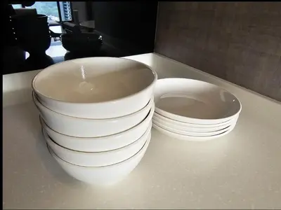 two stacks of white bowls and plates sitting on a counter at KL City Suites 2-4pax near KLCC & Bukit Bintang in Kuala Lumpur