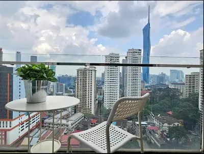 a balcony with a table and chairs and a city at KL City Suites 2-4pax near KLCC & Bukit Bintang in Kuala Lumpur