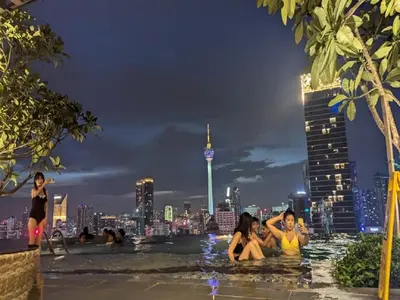 a group of people sitting in the pool at night at Axon Residence Kuala Lumpur Pavilion in Kuala Lumpur