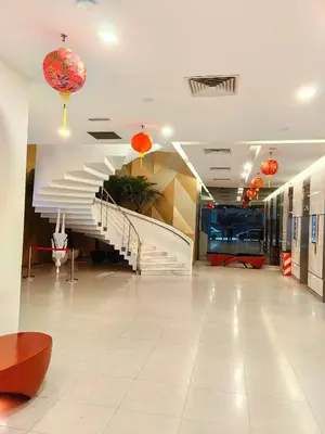 a lobby with a staircase in a building with orange lanterns at Summer Suites KLCC By Palace in Kuala Lumpur