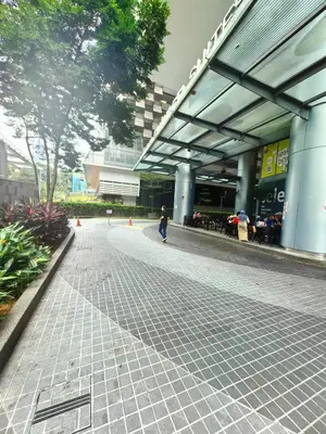 a person walking down a sidewalk in front of a building at Summer Suites KLCC By Palace in Kuala Lumpur