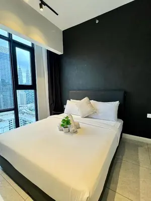 a bedroom with a large white bed with a black wall at Axon Infinity Pool KL in Kuala Lumpur