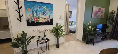 a living room with plants and a painting on the wall at Springtime 2bedrooms with KLCC view &Gorgeous pool in Kuala Lumpur