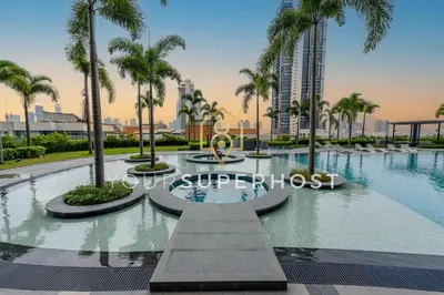 a swimming pool with palm trees in a city at Trion@KL by YourSuperhost in Kuala Lumpur