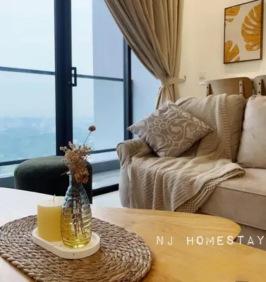 a living room with a couch and a table with a candle at NJ Homestay AT TRION, KL in Kuala Lumpur