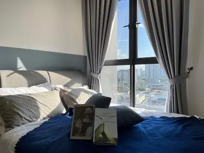 a bed with a book on it with a window at NJ Homestay AT TRION, KL in Kuala Lumpur