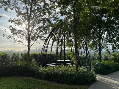 a park with a bench in the middle of trees at NJ Homestay AT TRION, KL in Kuala Lumpur