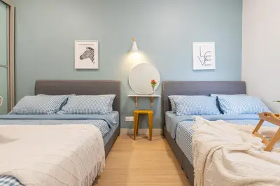 a bedroom with two beds and a mirror on the wall at Continew Residensi by Feel Home in Kuala Lumpur