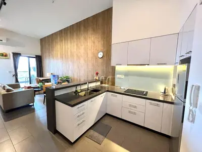 a kitchen with white cabinets and a living room at The EST Bangsar Kuala Lumpur in Kuala Lumpur