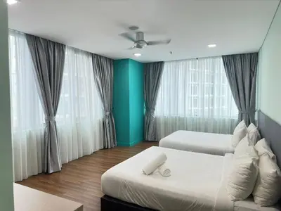 a bedroom with two beds and two windows at Summer Suites KLCC by Luna KL in Kuala Lumpur