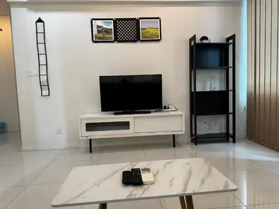 a living room with a tv on a white entertainment center at Summer Suites KLCC by Luna KL in Kuala Lumpur
