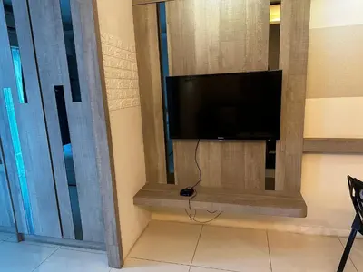 a flat screen tv in a room with a window at Summer Suites KLCC by Luna KL in Kuala Lumpur