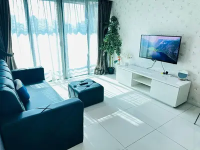 a living room with a couch and a flat screen tv at Summer Suites KLCC by Luna KL in Kuala Lumpur