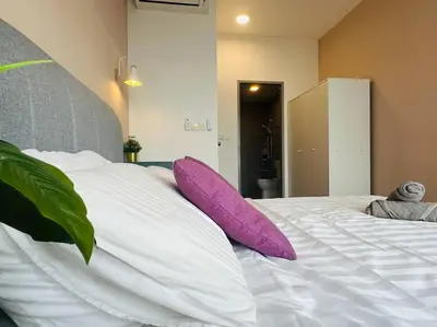 a large white bed with purple pillows on it at MVD19#Family Suite 8pax 3 Rooms M Vertica Velocity Mall Cheras IKEA Mytown Short Walk to MRT & LRT Maluri in Kuala Lumpur