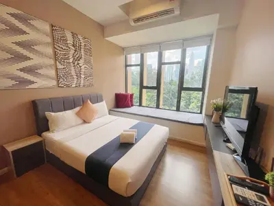 a bedroom with a large bed and a window at Ceylonz Suites By MyStay in Kuala Lumpur