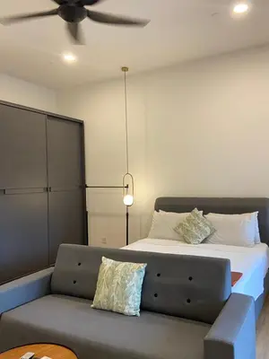 a bedroom with a bed with a couch and a ceiling fan at Ceylonz Suites By MyStay in Kuala Lumpur