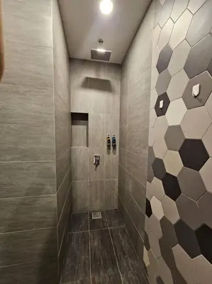 a bathroom with a shower with brown and gray tiles at Stylish Ceylonz Suite near Bukit Bintang 4pax in Kuala Lumpur