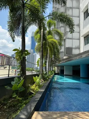 a swimming pool with palm trees and a building at Cozy home in city center with free parking -1B in Kuala Lumpur