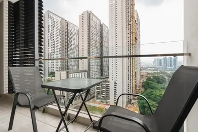 a table and chairs on a balcony with a view of a city at Sentul Homestay 3 Bedroom in Kuala Lumpur