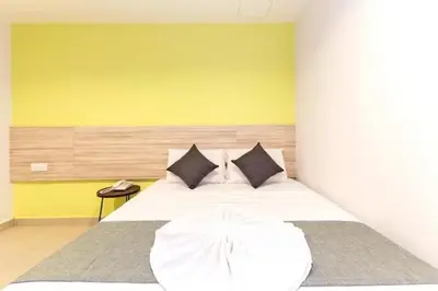 a bedroom with a large white bed with black pillows at M HOTEL - Medan Tuanku Near MARA in Kuala Lumpur