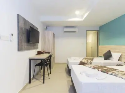 a room with two beds and a table and a tv at M HOTEL - Medan Tuanku Near MARA in Kuala Lumpur