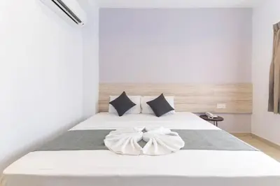 a bedroom with a white bed with two pillows at M HOTEL - Medan Tuanku Near MARA in Kuala Lumpur