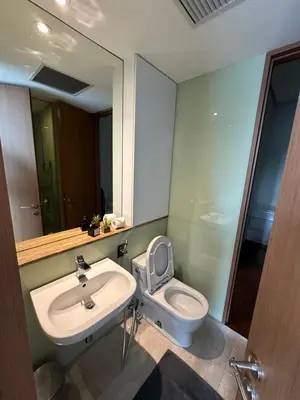 a bathroom with a toilet and a sink and a mirror at Soho Suites KLCC 20 jalan perak in Kuala Lumpur