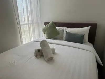 a white bed with a remote control on it at Soho Suites KLCC 20 jalan perak in Kuala Lumpur