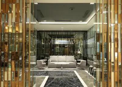 a lobby with a couch in a room with glass walls at Luxhouz Suites at Times Square Kuala Lumpur in Kuala Lumpur