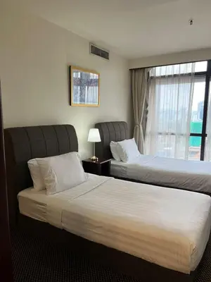 a hotel room with two beds and a window at Luxhouz Suites at Times Square Kuala Lumpur in Kuala Lumpur