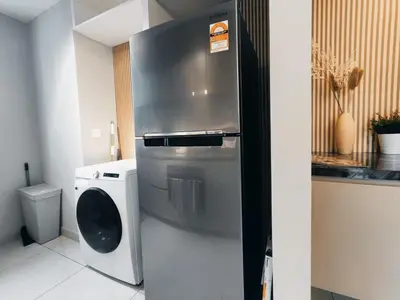 a kitchen with a stainless steel refrigerator and a washing machine at Datum Jelatek Residences Royalty Luxury Apartment, Walking Distance To LRT, Gleneagles KL & KLCC in Kampong Datok Keramat