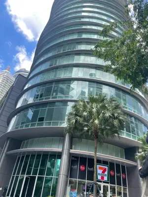 a tall building with a palm tree in front of it at Vortex Suites KLCC by ZARA in Kuala Lumpur