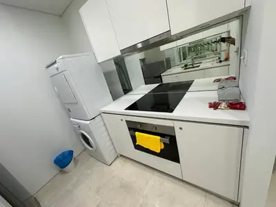 a white kitchen with a stove and a refrigerator at Vortex Suites KLCC by ZARA in Kuala Lumpur