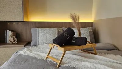 a bed with two pillows on top of it at Neu Suites in Kuala Lumpur